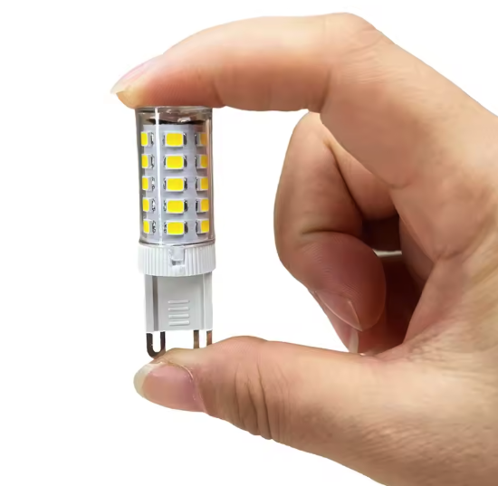 A small G9 LED bulb held between two fingers for scale